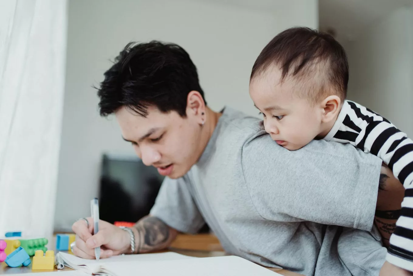 un père qui travaille en gardant son bébé